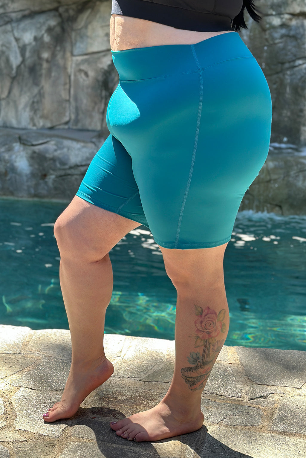 Side closeup view of size 2x plus size swim shorts in teal