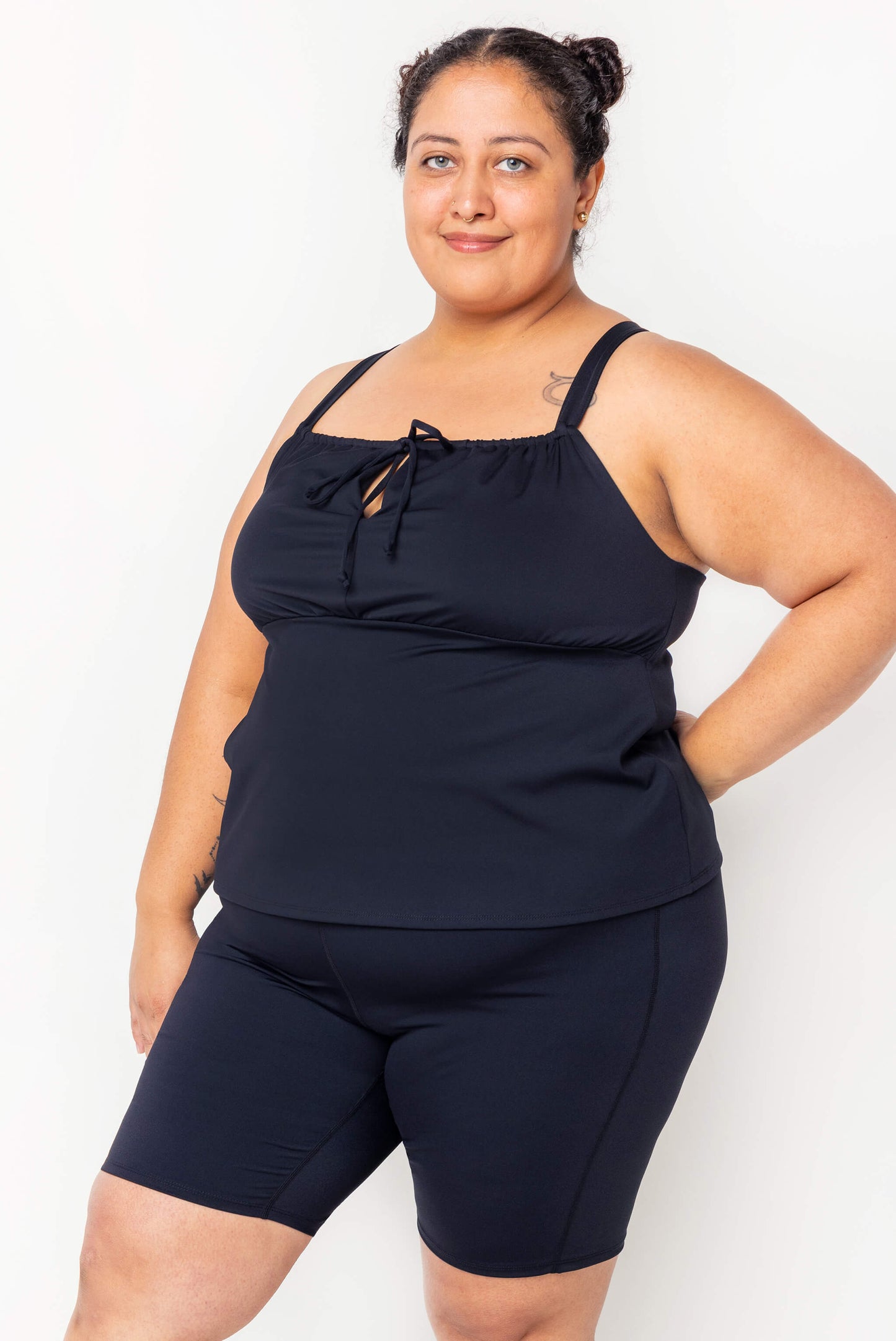 Profile view of model wearing black Plus size swim tankini size 2X