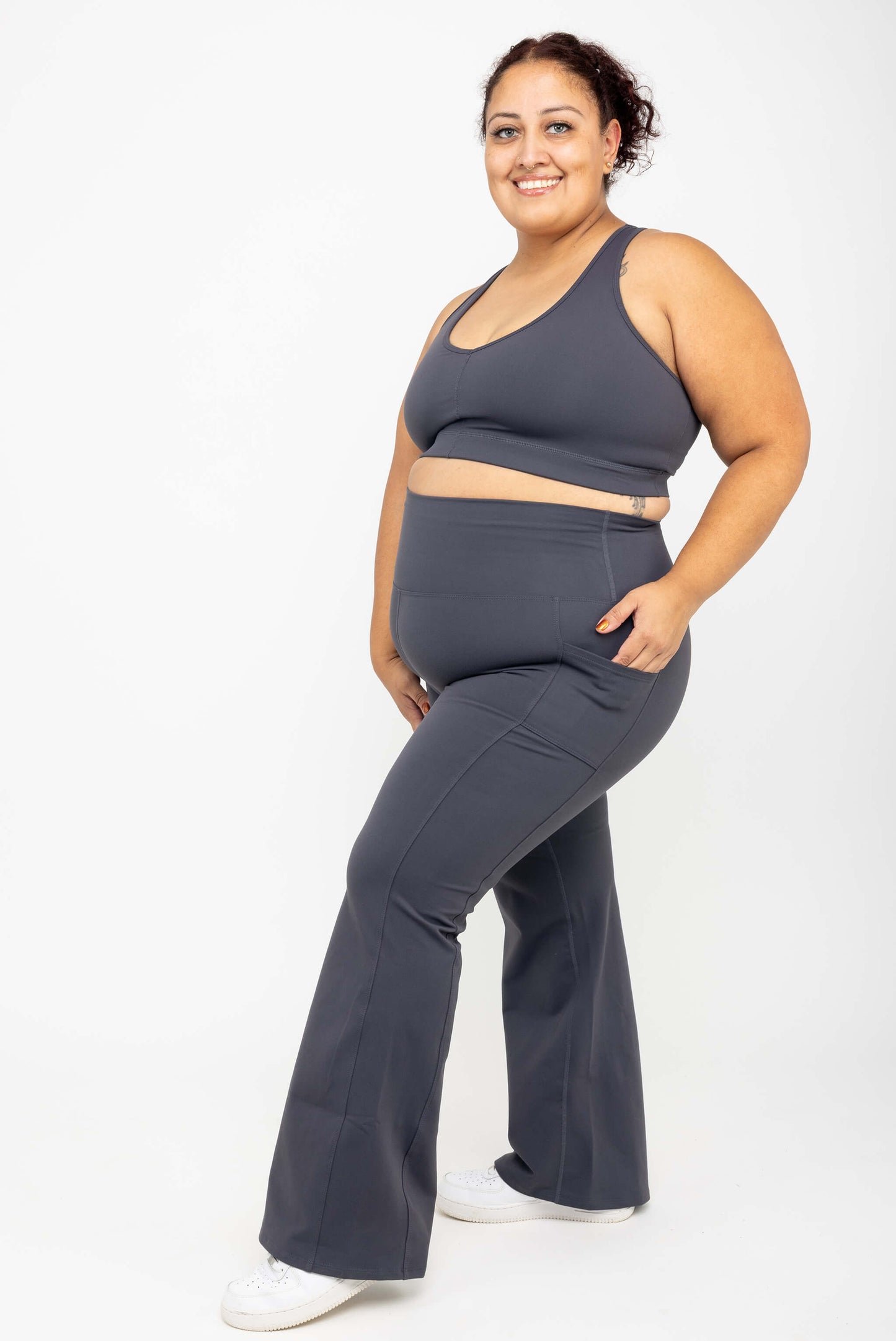 Model wearing SuperHold™ Flare Pocket Leggings in Color Carbon, size 2X with matching V-neck Sports bra