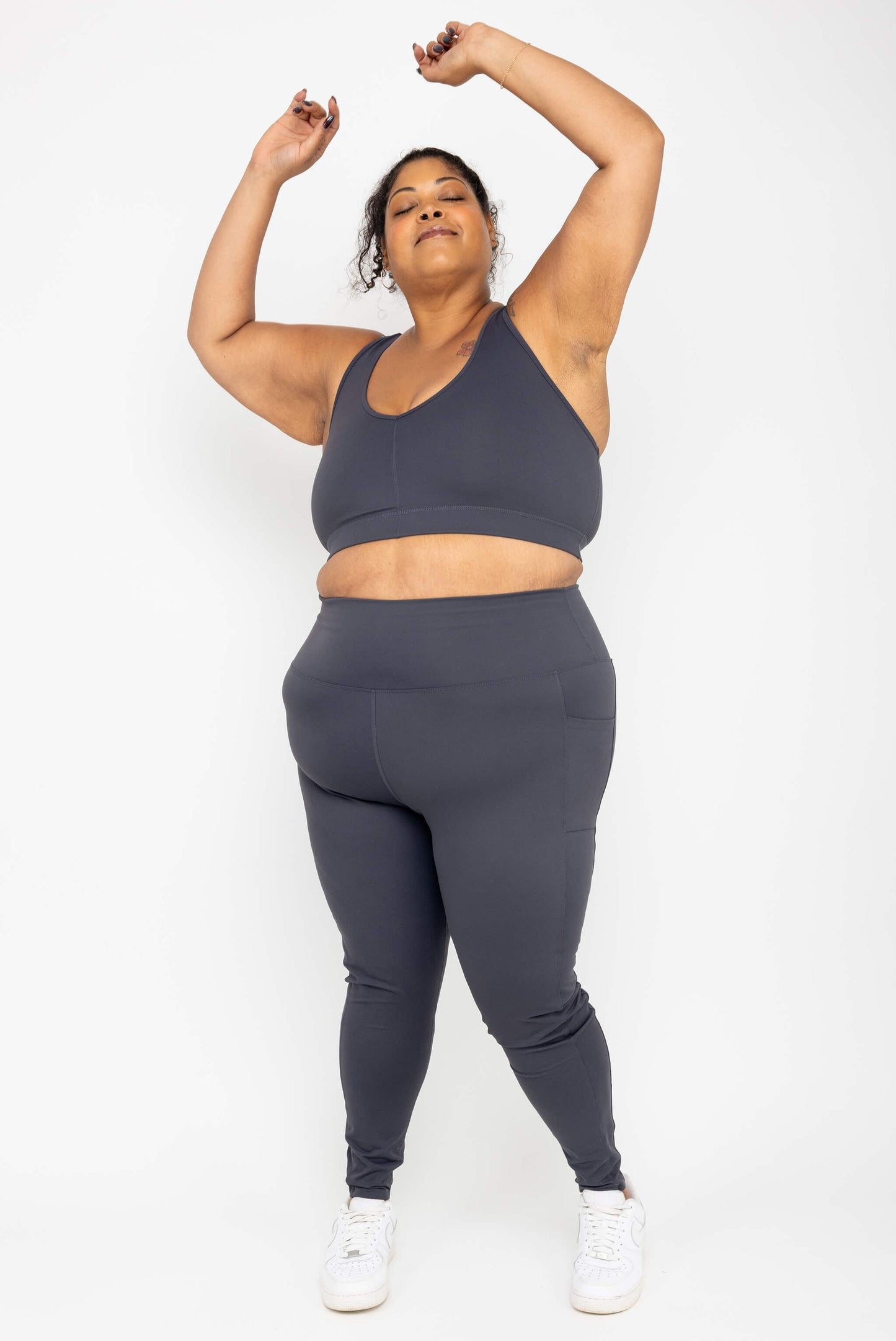 Model with her arms up, wearing Superfit Hero SuperHold™ Ankle Leggings, color Carbon, Size 3X