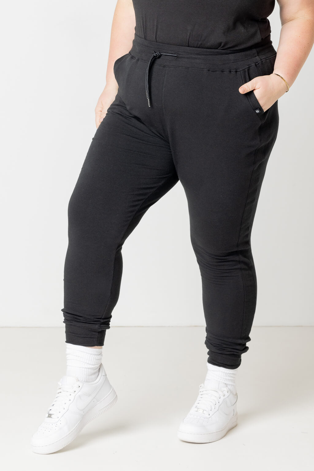 Plus size model wearing Superfit Hero black joggers in size XL