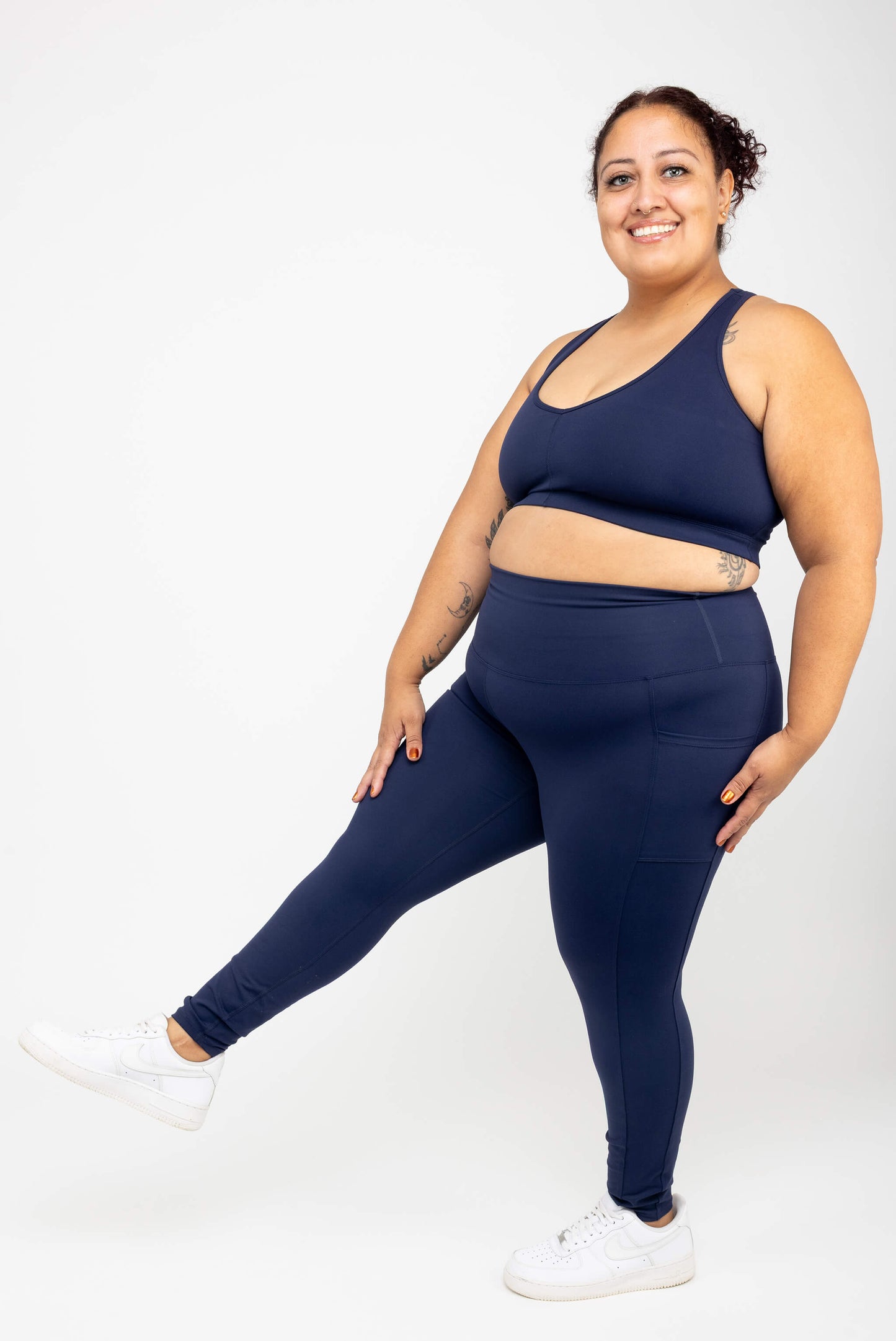 Model kicking her leg out, wearing Superfit Hero SuperHold™ 7/8 Leggings, color Navy, Size 2X