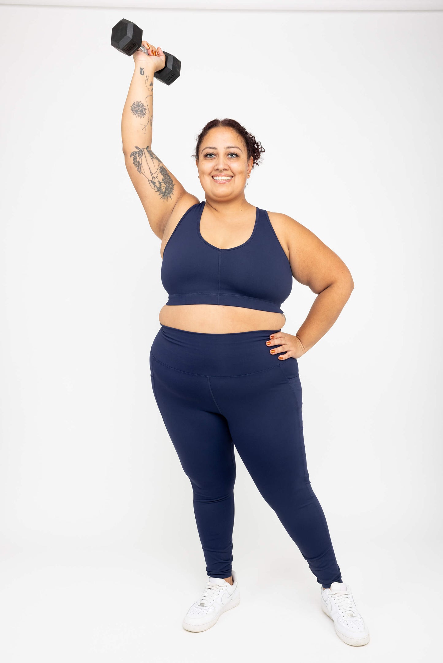 Model holding dumbbell overhead, wearing Superfit Hero SuperHold™ V-neck Sports Bra, color Navy, size 2X