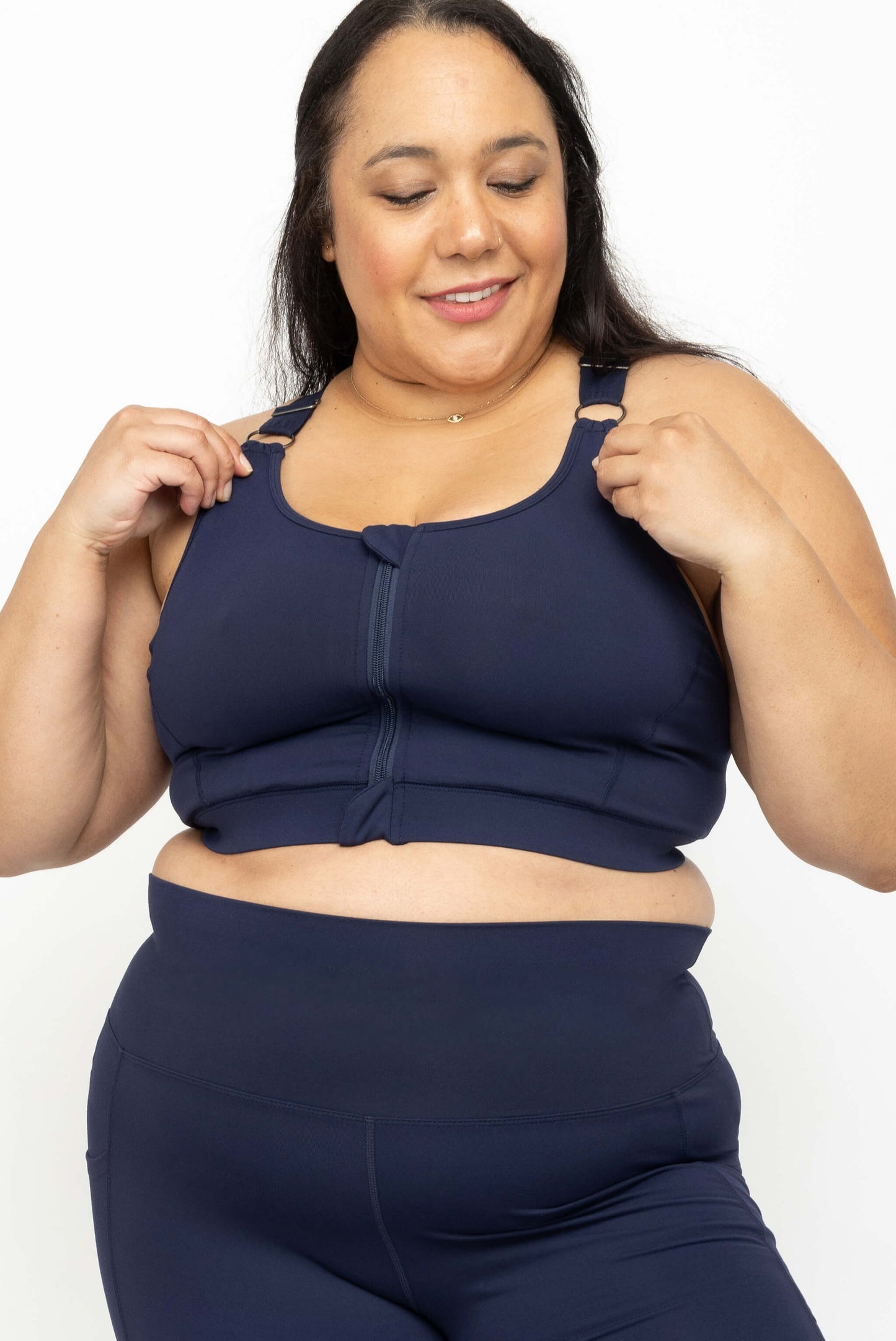 Model showing off adjustable straps on Superfit Hero plus size zip front sports bra, navy, size 2X