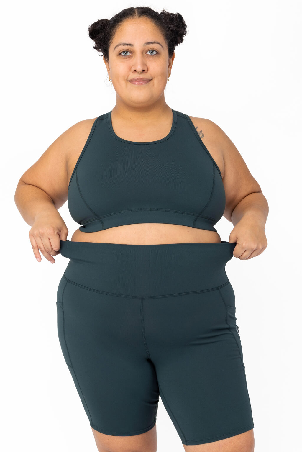 Size 2X model showing off the stretchy waistband of plus size biker shorts with pockets