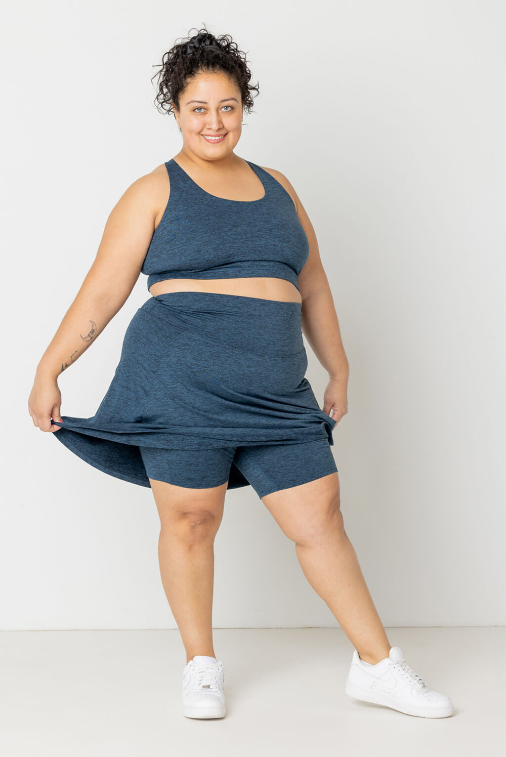 Size 2X model shows off shorts under plus size skort in heather navy