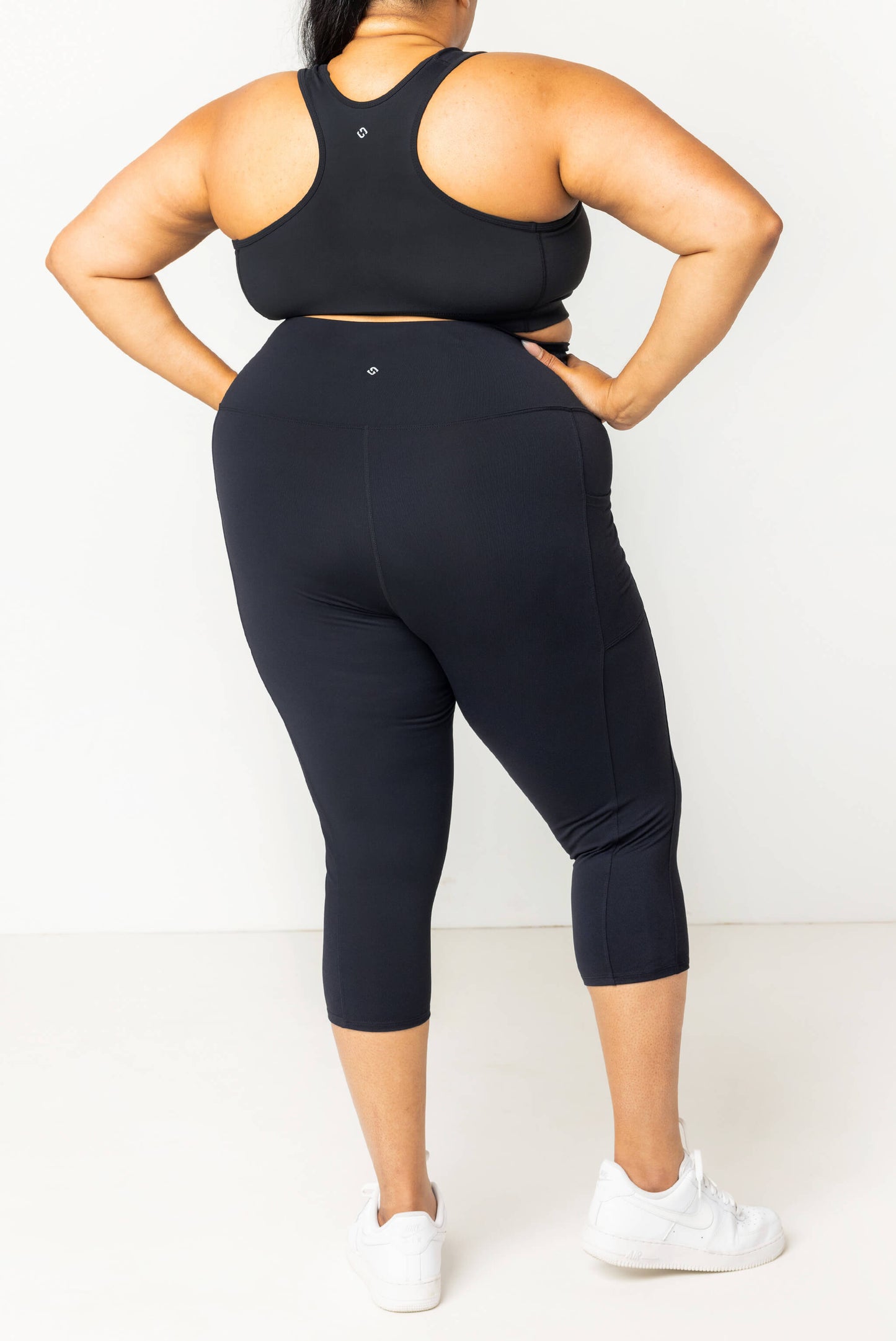 Back view of plus size model wearing black SuperHold pocket capris in size 2x