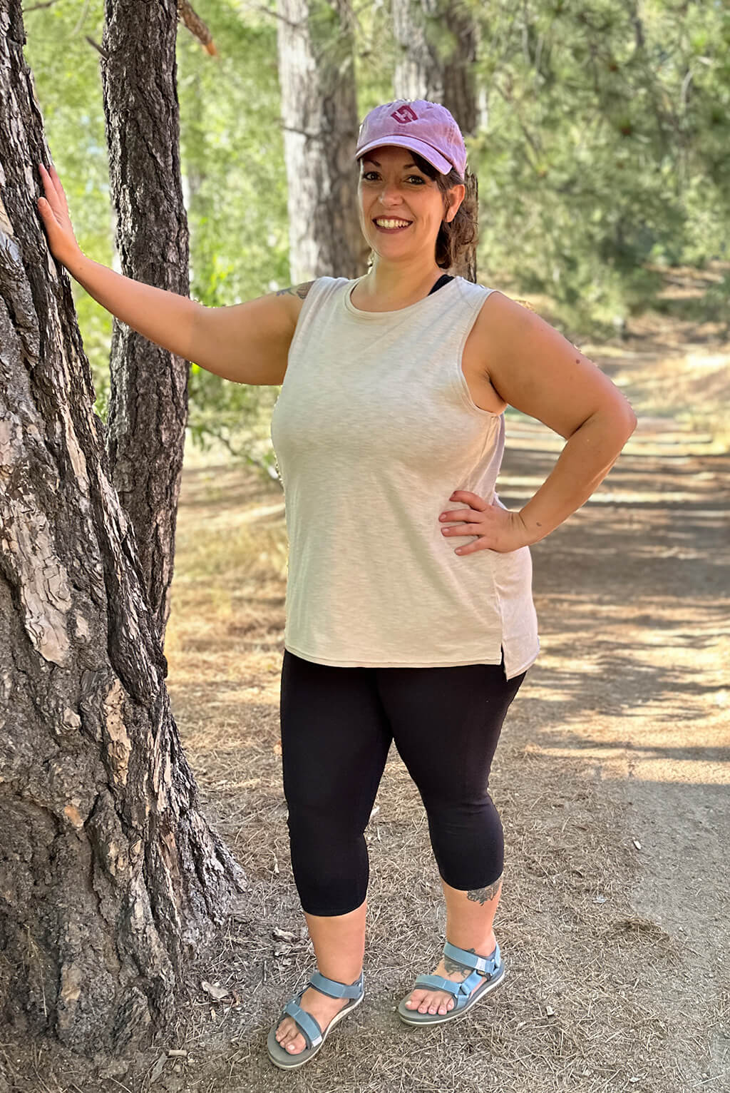 Full body shot of model with hand on tree wearing textured muscle tank.