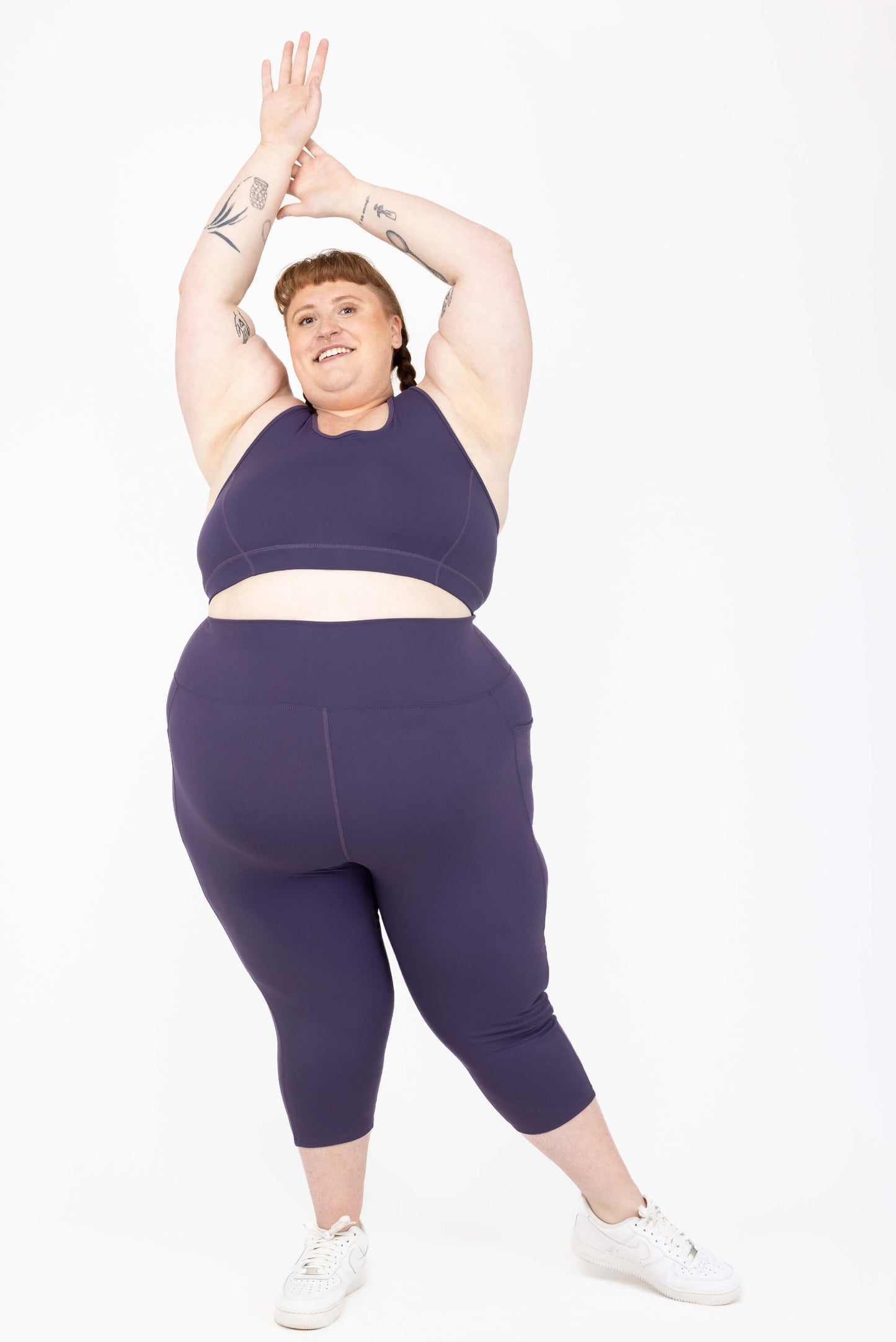 plus size model wearing purple capri leggings with pockets size 5x