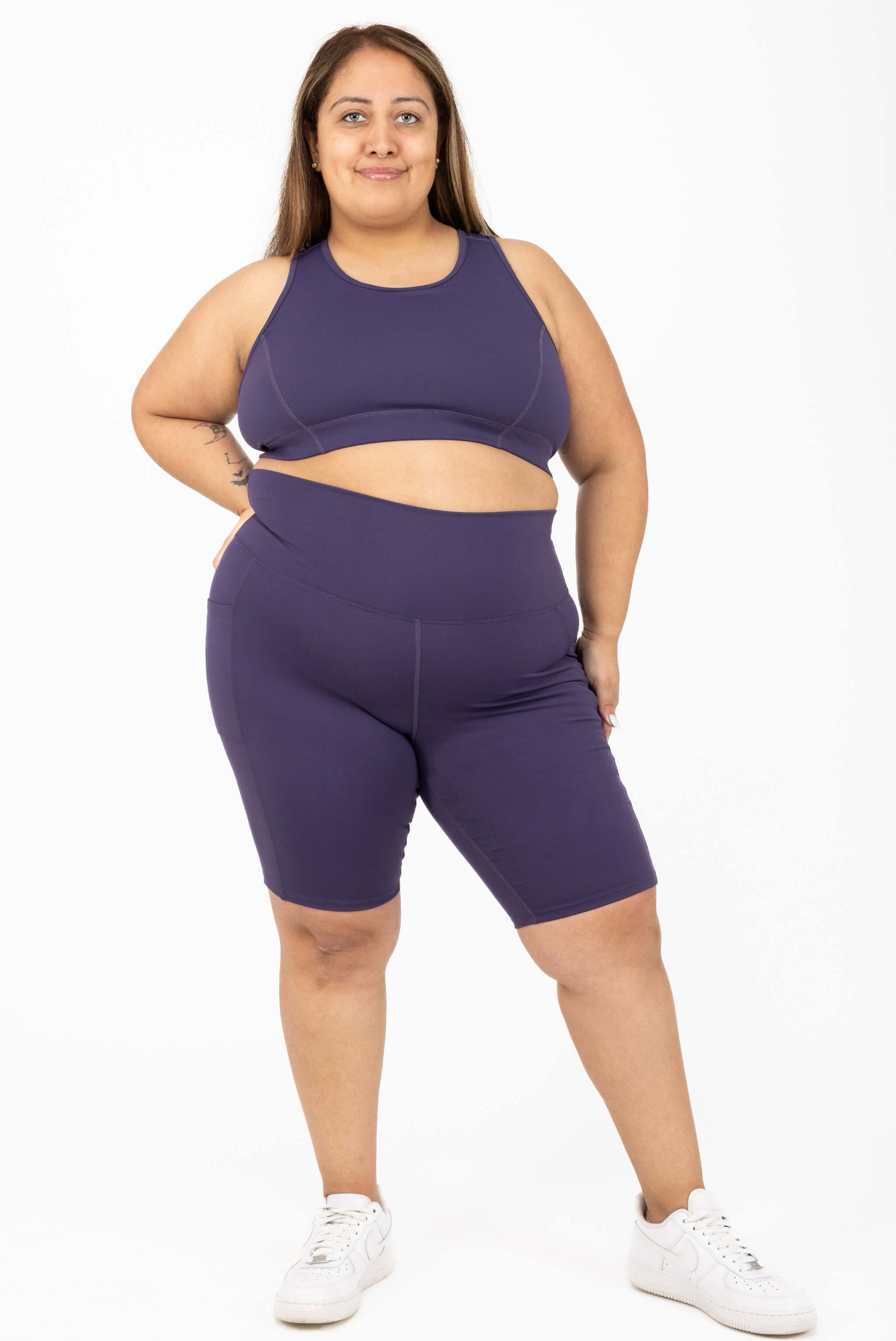Model wearing Plus size 11 inch pocket shorts deep purple size 2X