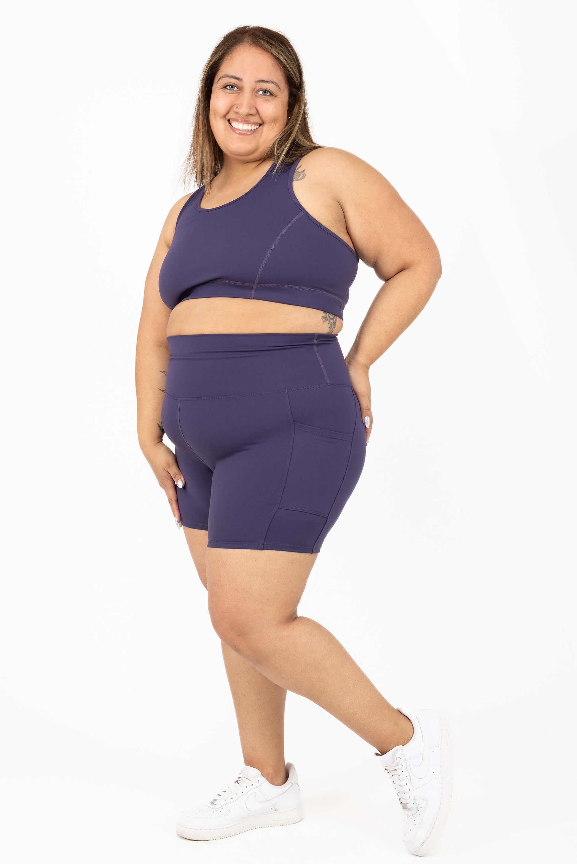 Happy model wearing 6 inch plus size pocket shorts deep purple size 2x