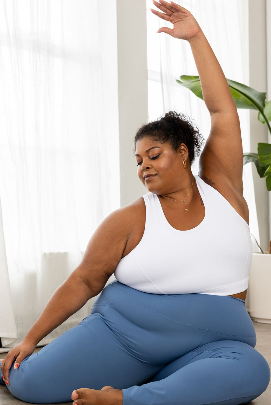 plus size model doing yoga in white racerback bra size 3X