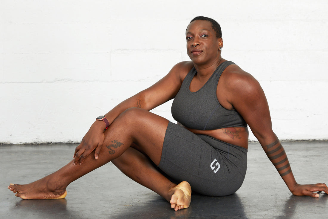Plus size woman wearing Superfit Hero Superhold bike shorts and sports bra in Charcoal.