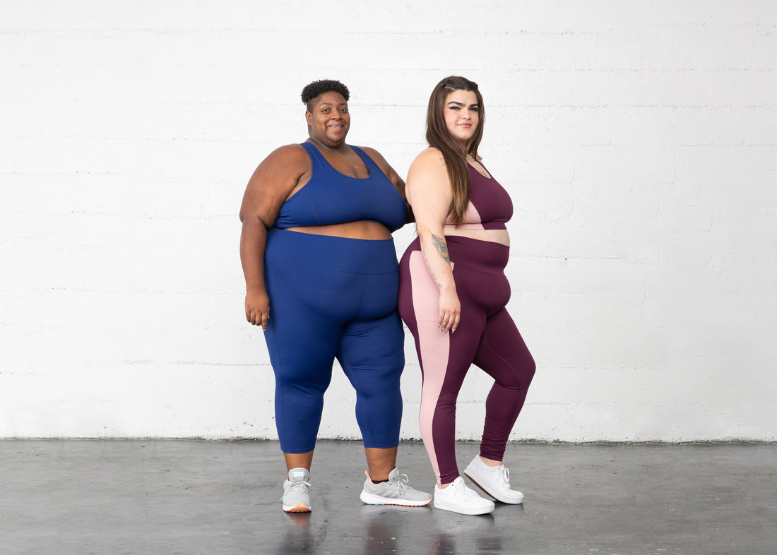 Plus size women wearing Superfit Hero's Superhold Collection sports bra and leggins burgundy/blush and cobalt.