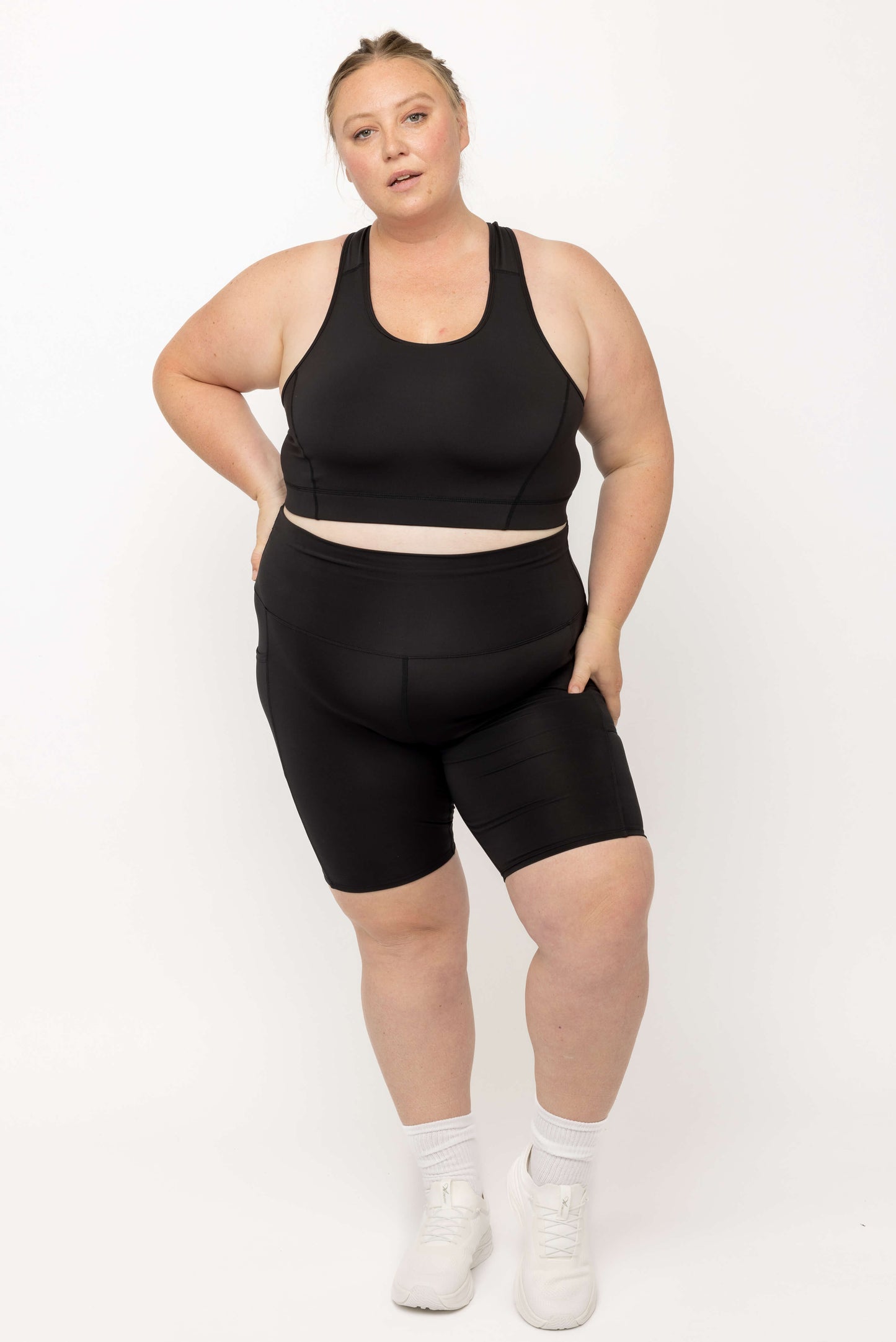 Model posing in matching set of Black SuperCool 9 inch shorts and Sports Bra, size 2X