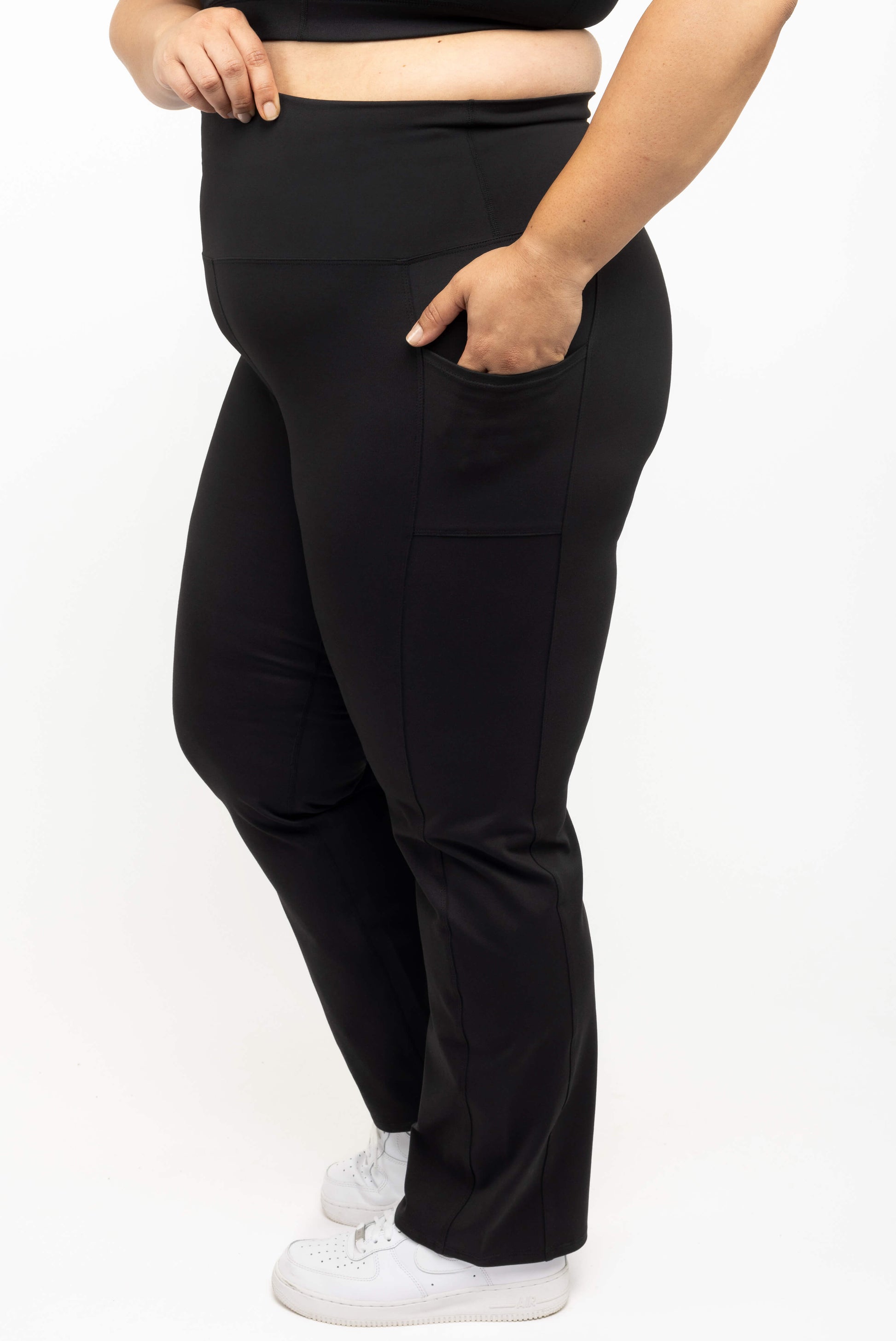 Profile view of Plus size model with her hand in pockets of Superfit Hero straight legg leggings size 2X