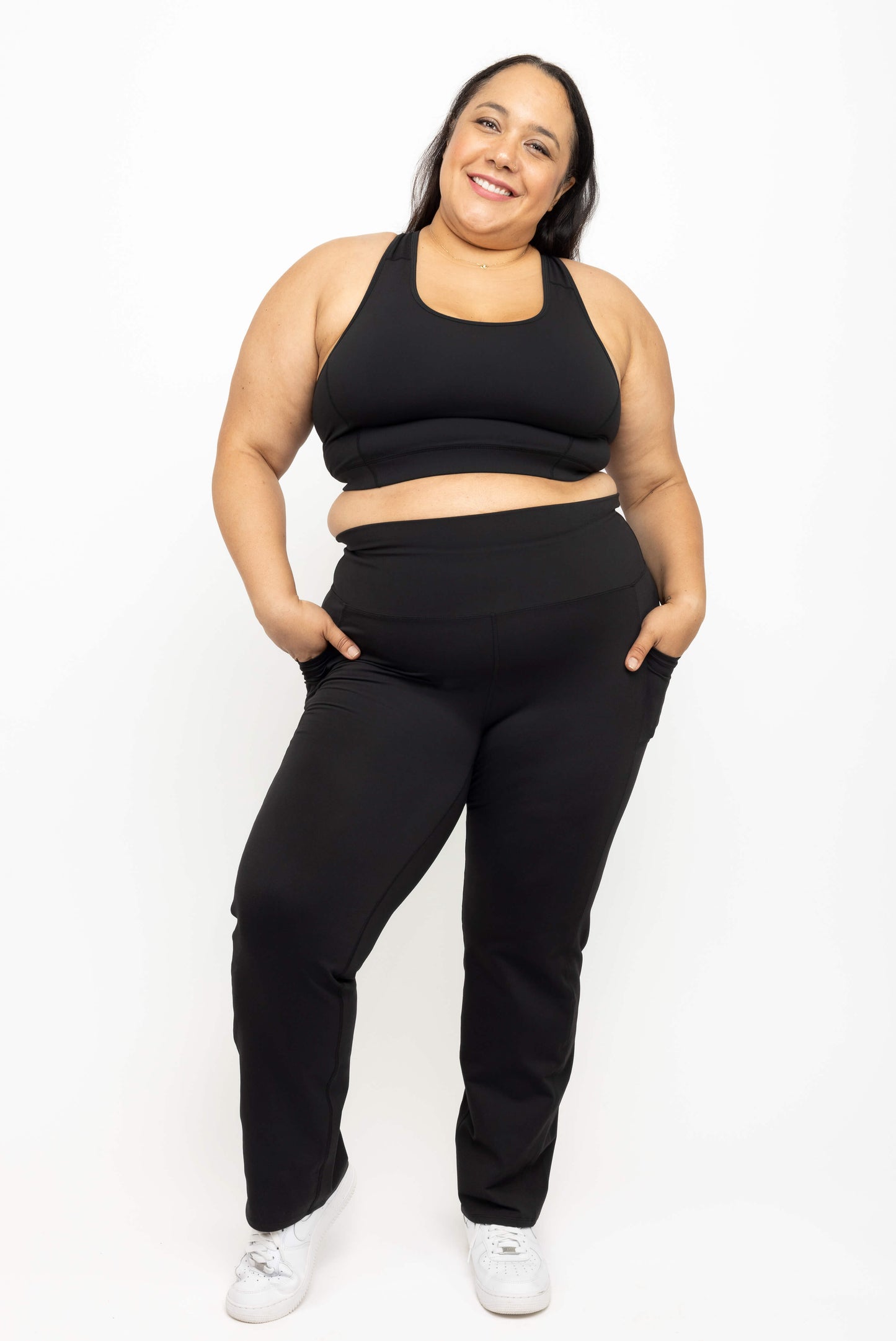 Plus size model smiling with her hands in pockets of Superfit Hero straight legg leggings size 2X