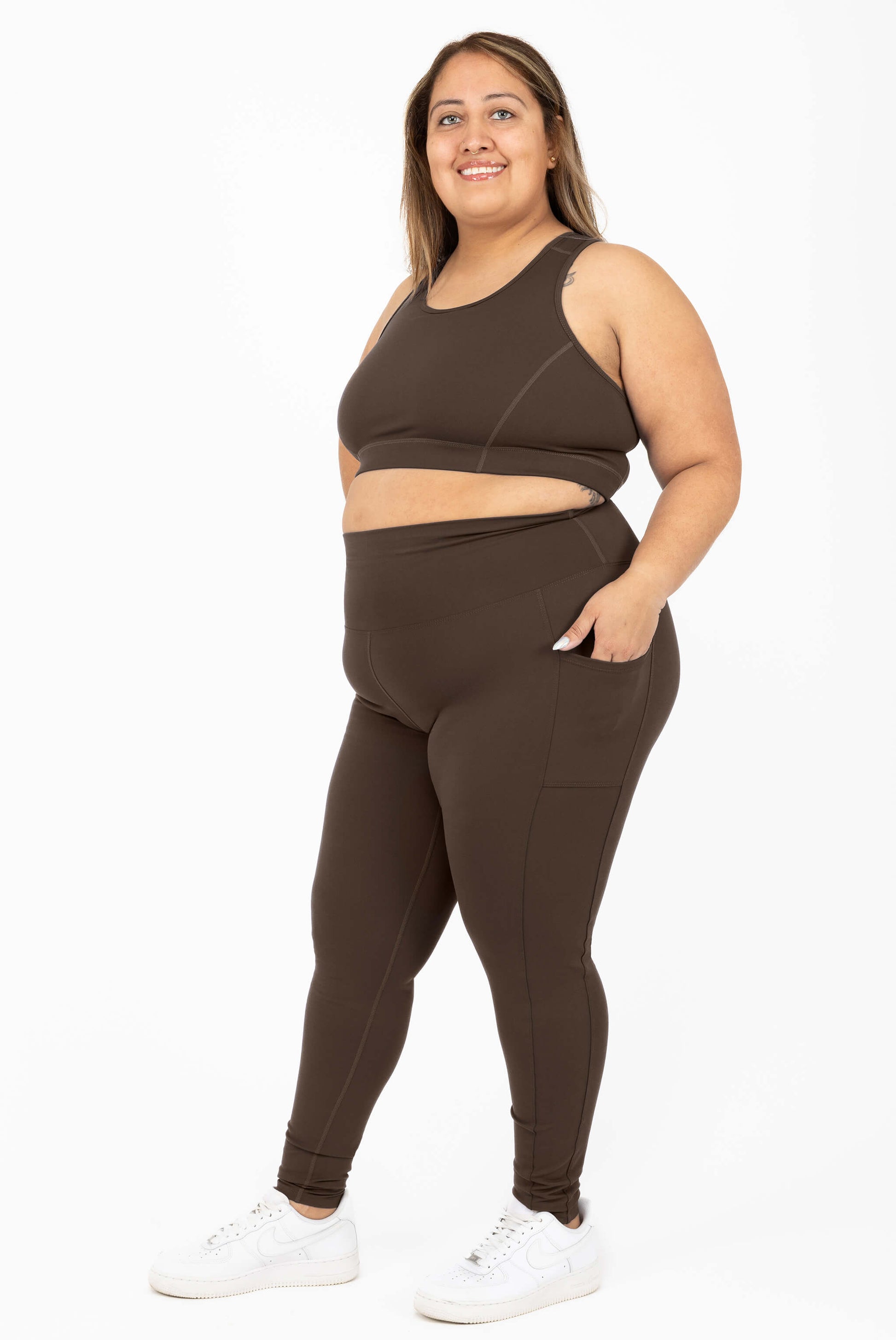Model wearing SuperHold Ankle Leggings Chocolate Brown, with hand in pockets Size 2X