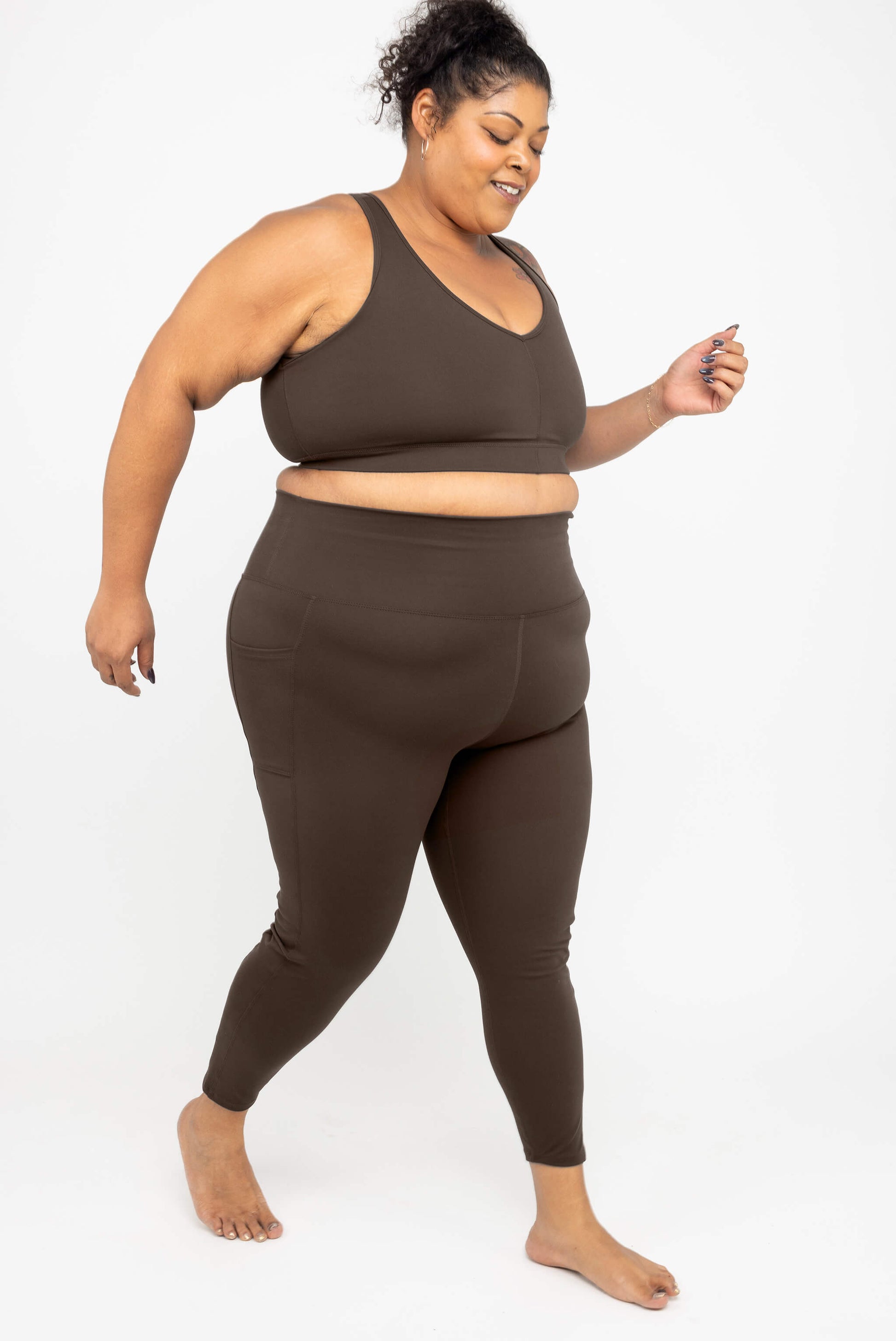 Model stepping forward wearing SuperHold 7/8 leggings with pocket, size 3X, Chocolate Brown