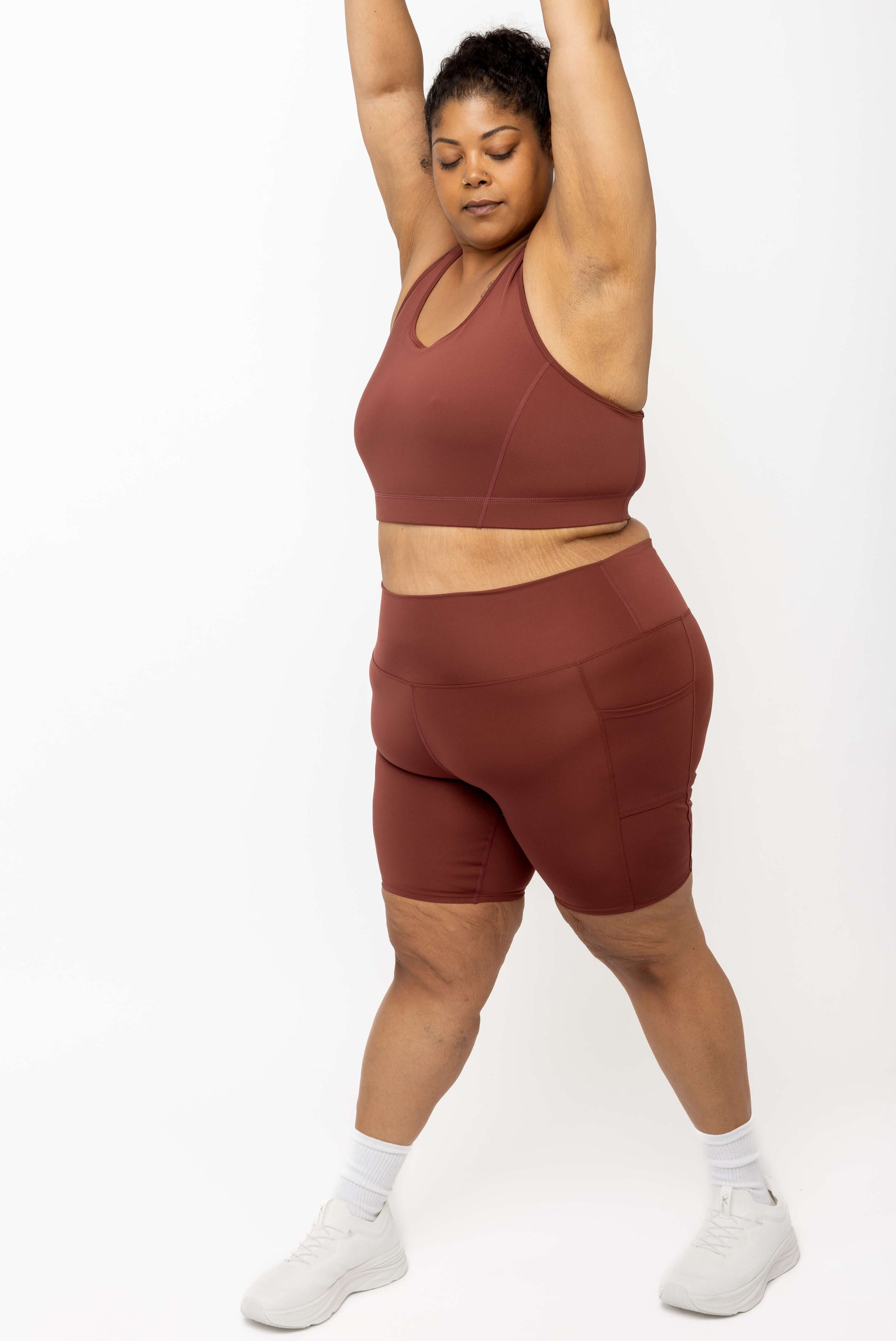 Image of model stretching her arms up wearing Cinnamon SuperCool 9 inch shorts size 2X