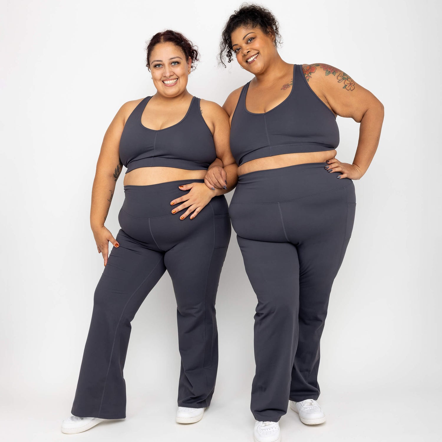 Two models wearing matching Superfit Hero flare leggings and V-neck Sports Bras, color Carbon