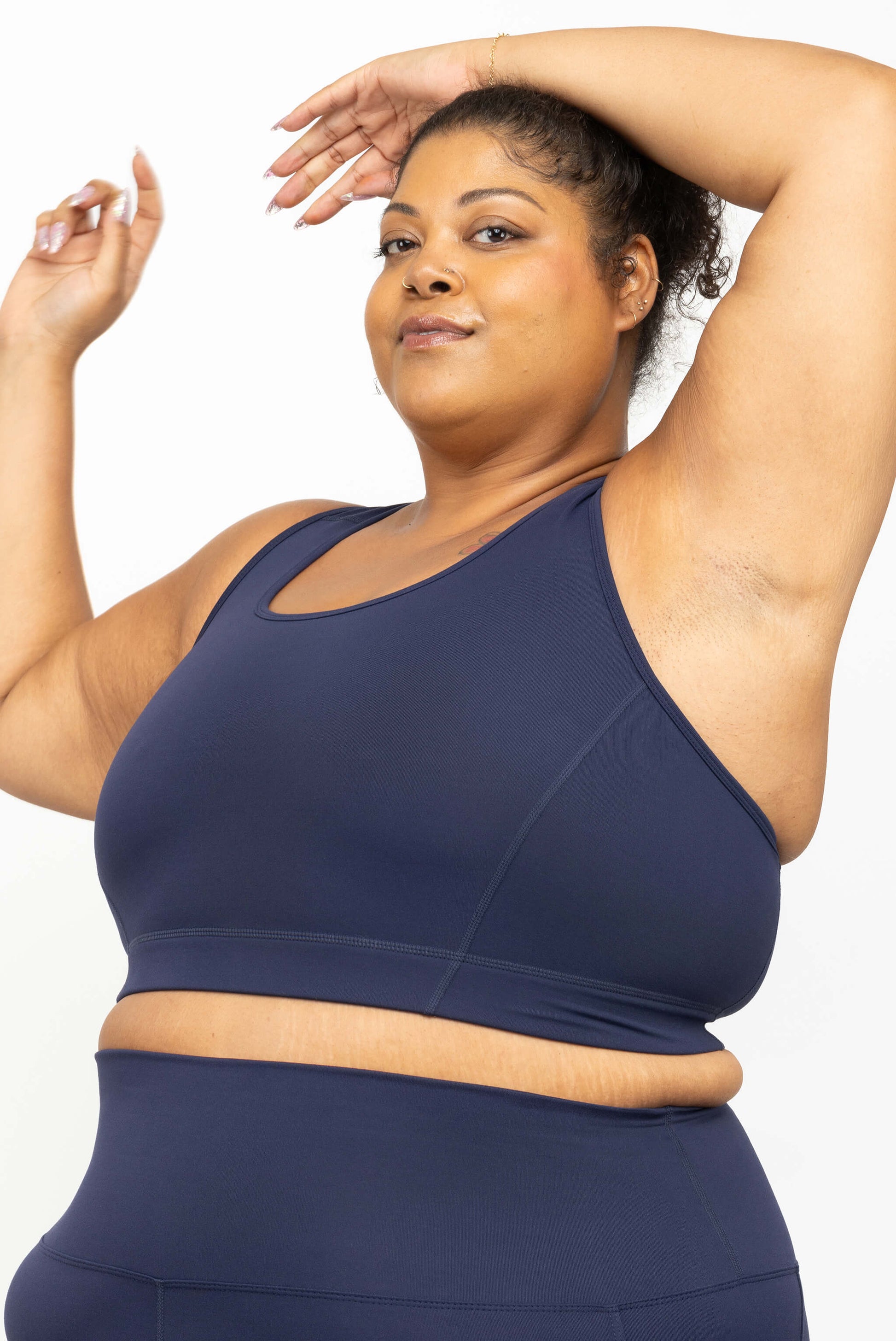 Model showing the underarm coverage of Superfit Hero's plus size racerback bra in size 3X, color navy