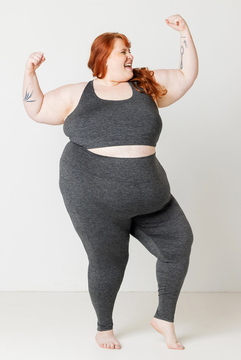 Plus size model posing with strong arms in Superfit Hero SuperSoft Pocket leggings in Size 5X