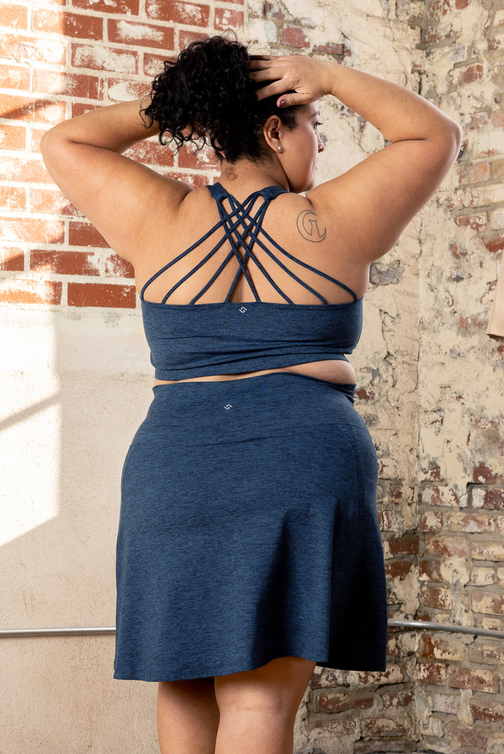 Back view of plus size model wearing Superfit Hero Supersoft skort in heather navy