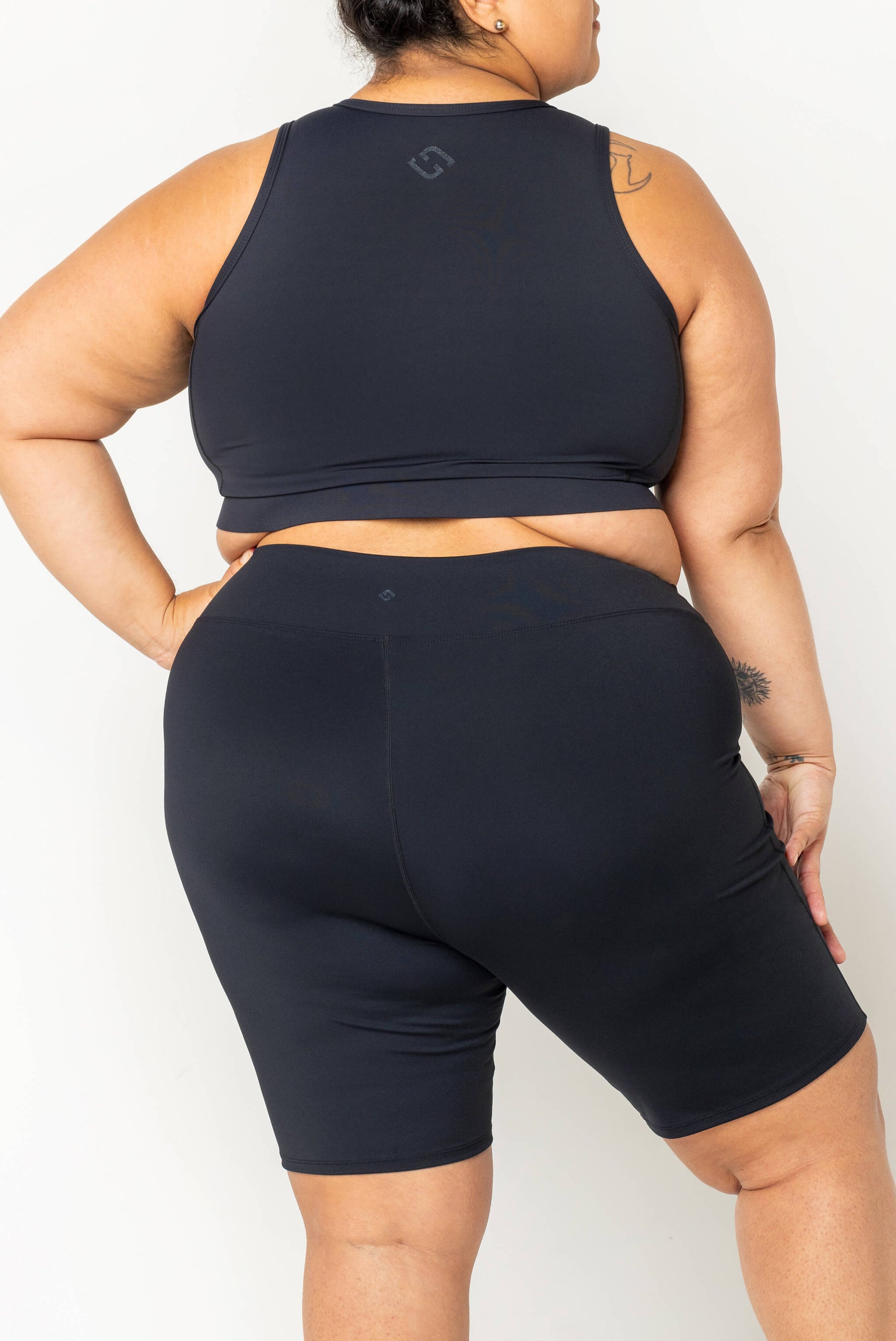 Back view of plus size model wearing half zip crop bikini black
