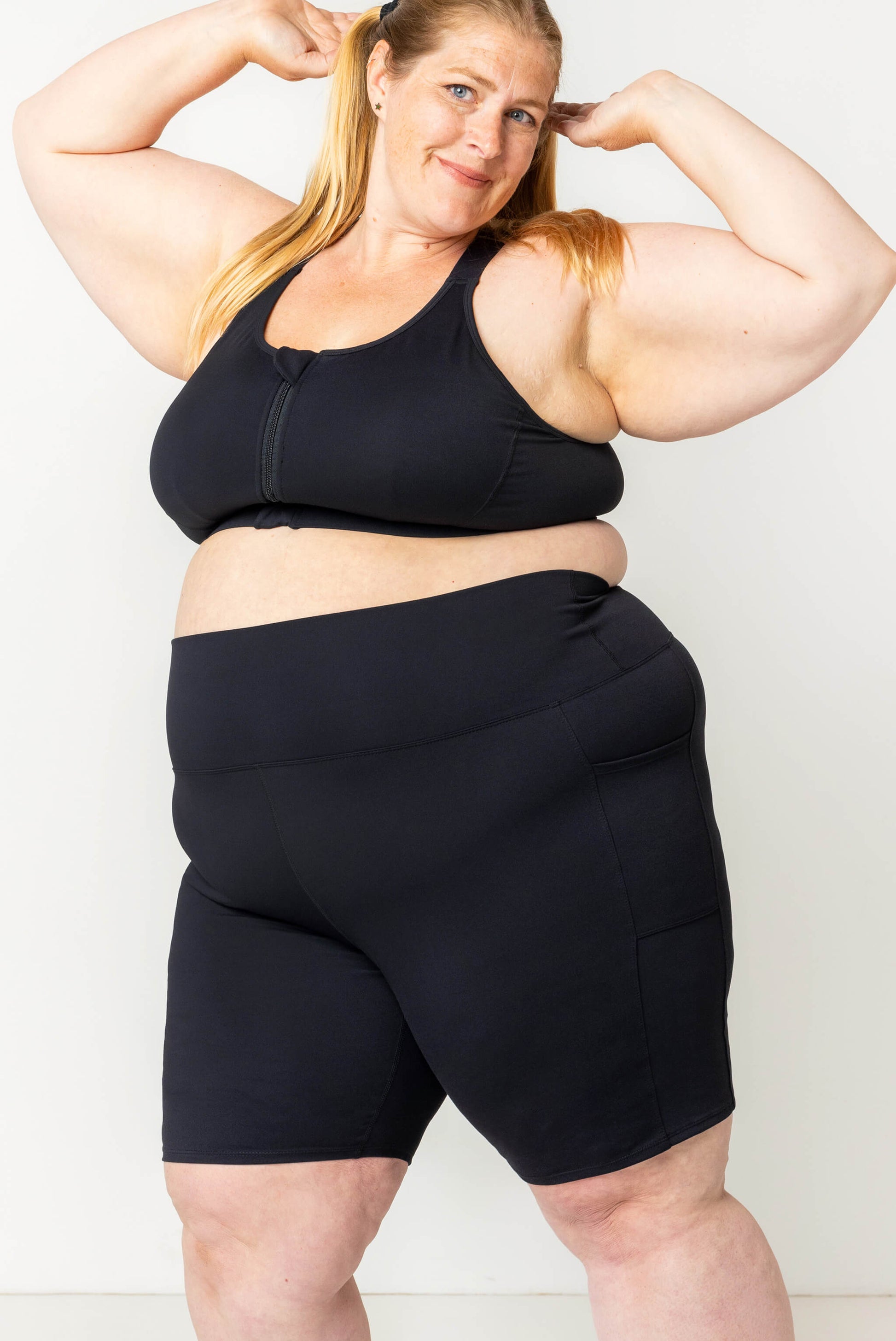 plus size model with arms up, modeling size 4X pocket bike shorts in compression fabric