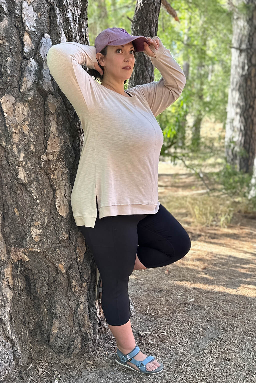 Profile view of plus size textured long sleeve top on model in the woods.