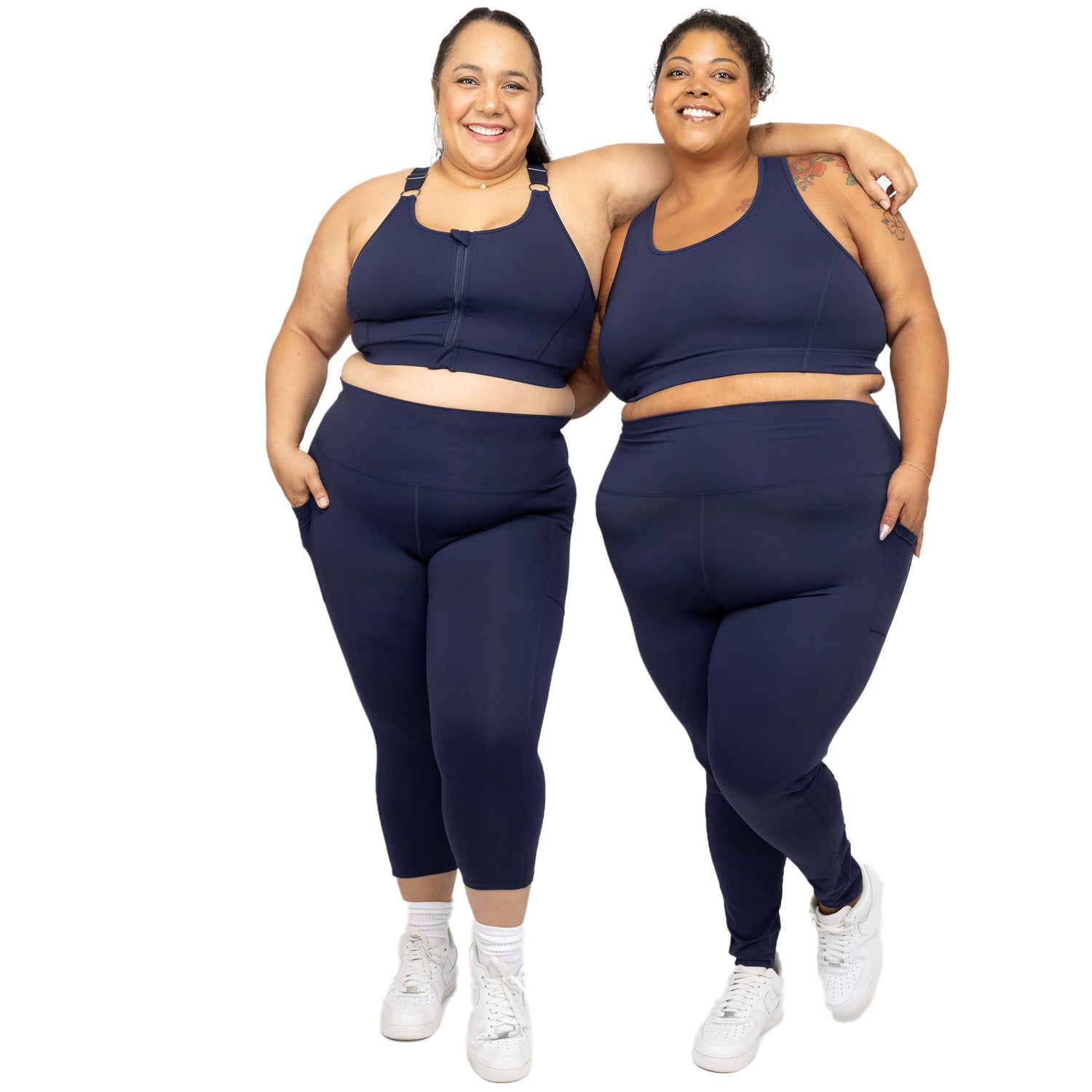 Two plus size models wearing navy Superfit Hero leggings and sports bras size 2X and 3X